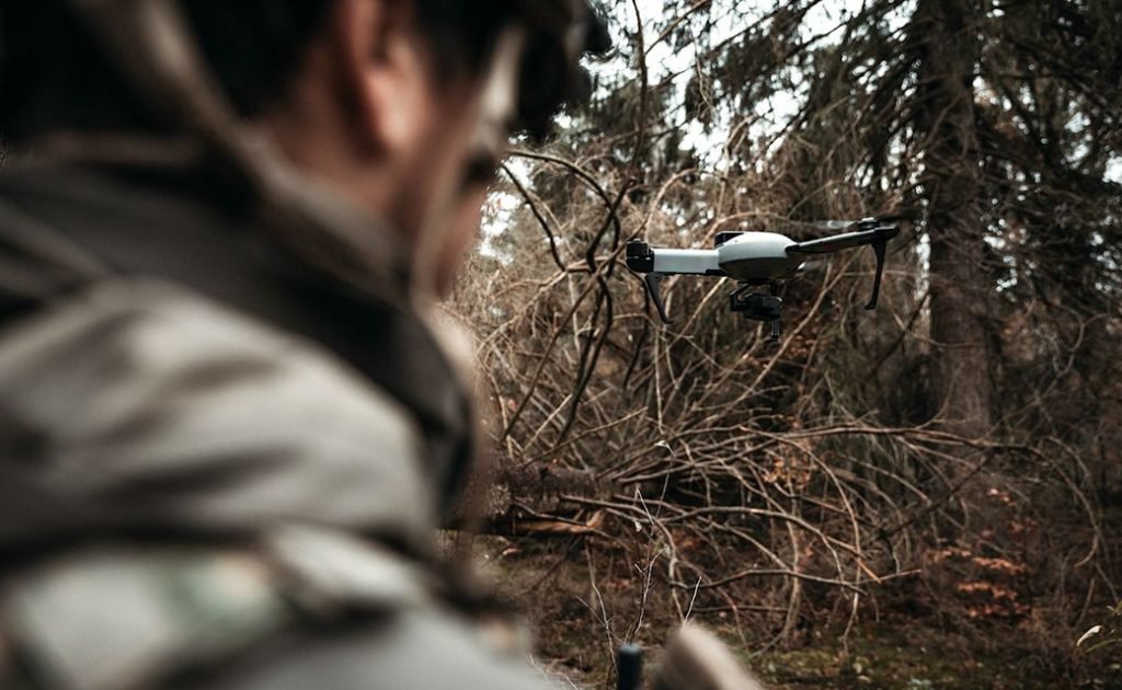 Drone léger tri-coptère AtlasPRO en action, piloté par un opérateur pour des missions de surveillance et de reconnaissance.